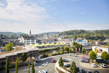 Blick über den Kreisel und den Parkplatz in der Wilhelmstraße, im Hintergrund die Fußgängerbrücke und der Busbahnhof